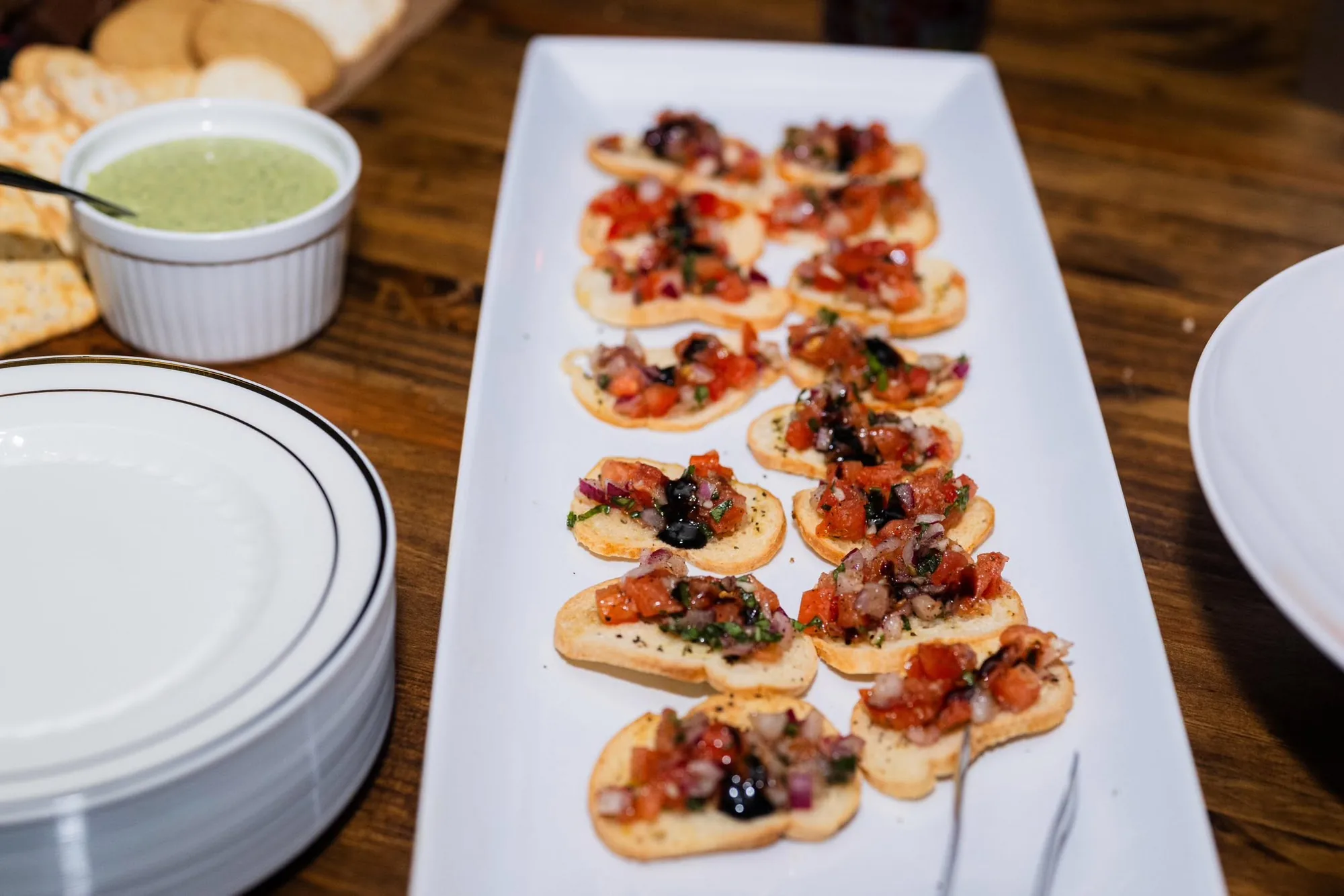 Tomato bruschetta crostini on a white platter